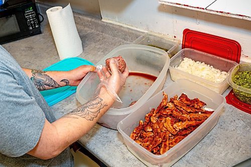 NIC ADAM / FREE PRESS
Brenden Galbichka, cook at Brian&#x2019;s and son of Tessa, pictured making a monster burger, one of two customer favourite burgers, in the kitchen of Brian&#x2019;s Drive-Inn Wednesday.
240731 - Wednesday, July 31, 2024.

Reporter: Dave
