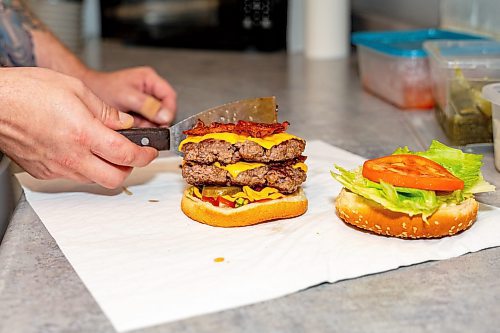 NIC ADAM / FREE PRESS
Brenden Galbichka, cook at Brian&#x2019;s and son of Tessa, pictured making a monster burger, one of two customer favourite burgers, in the kitchen of Brian&#x2019;s Drive-Inn Wednesday.
240731 - Wednesday, July 31, 2024.

Reporter: Dave
