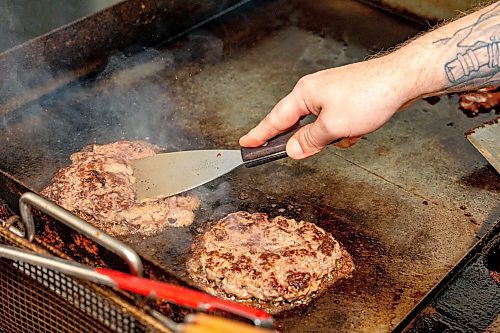 NIC ADAM / FREE PRESS
Brenden Galbichka, cook at Brian&#x2019;s and son of Tessa, pictured making a monster burger, one of two customer favourite burgers, in the kitchen of Brian&#x2019;s Drive-Inn Wednesday.
240731 - Wednesday, July 31, 2024.

Reporter: Dave
