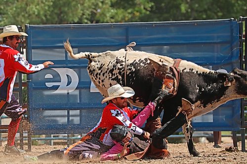 Baird hangs on as his steer pulls ahead while another rodeo protection team member rushes to the scene. (Tim Smith/The Brandon Sun)