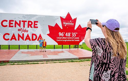 NIC ADAM / FREE PRESS
Vienna, Harper, and Griffin Swallow (from left) get their photo taken by their mother Tiffany at the longitudinal centre of Canada, just off hwy 1 Tuesday.
240723 - Tuesday, July 23, 2024.

Reporter: Jura