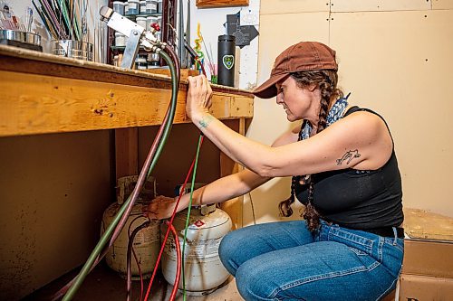 NIC ADAM / FREE PRESS
Glass worker Brook Drabot pictured turning on the propane in the garage studio of her Warren home Friday. Brook loves making very small things, blowing glass to create tiny vases, miniature ornaments and small bowls. 
240801 - Thursday, August 01, 2024.

Reporter: