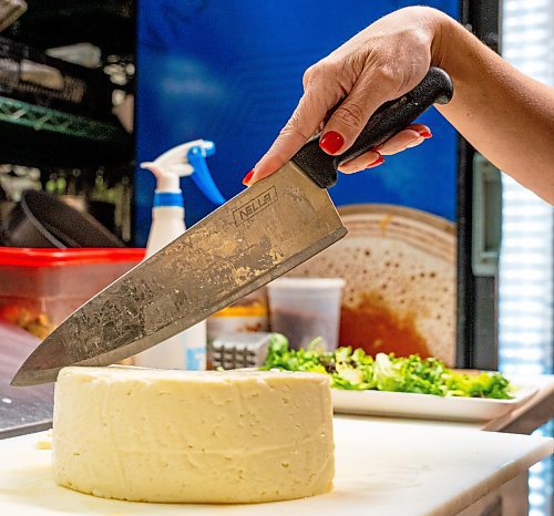 NIC ADAM / FREE PRESS
Brazilian cheese maker Fabiola Della Pria pictured cutting into a wheel of Minas frescal cheese in Hermano&#x2019;s restaurant in the Exchange District Tuesday. Last month Fabiola's Minas frescal cheese won 2nd place in an international competition in Buffalo, NY. that Hermano's is creating a salad and burger with.
240806 - Tuesday, August 06, 2024.

Reporter: Dave