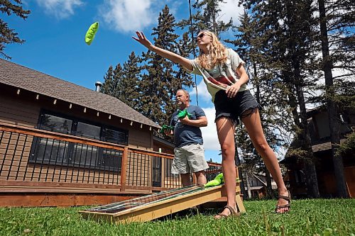 Lola Brady throws a beanbag while playing cornhole with family, including her grandfather Brian Seeman, in Wasagaming on a warm Wednesday afternoon. (Tim Smith/The Brandon Sun) 