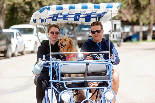 Britany Macovichuk and Jayden Nickel ride through Wasagaming in a family pedal bike along with Jayden’s dog, Penny, on Wednesday. (Tim Smith/The Brandon Sun)