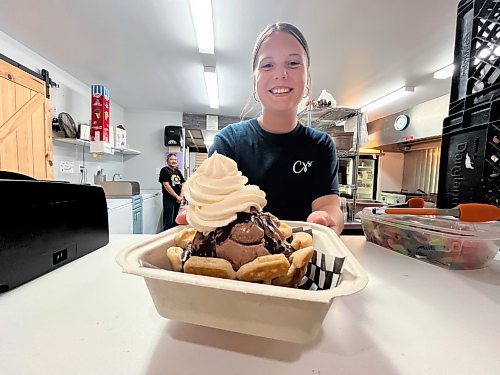 CJ's Snack Shack staffer Jill Hamm shows off one of the Rivers drive-in's own creations called Gracie's warm waffle bowl sundae for $8. Two scoops of hard ice cream with your choice of hot fudge, chocolate, strawberry or caramel sauce on a soft, freshly-made waffle made in the shape of a bowl. With whipped cream. (Matt Goerzen/The Brandon Sun)