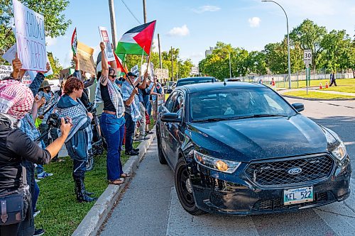 NIC ADAM / FREE PRESS
Protesters for Palestine yell shame at WPS after blocking the group with cruisers across the street from the Israel pavilion at Folklorama at the Asper Jewish Community Campus Wednesday.
240807 - Wednesday, August 07, 2024.

Reporter: Jura