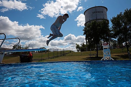 Leland Henderson leaps off the diving board at the Kinsmen Centennial Pool in Brandon’s Rideau Park while swimming with his cousin, Karter Henderson, on a windy Thursday. (Tim Smith/The Brandon Sun)