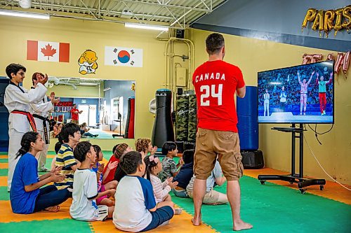 NIC ADAM / FREE PRESS
TRP Academy head instructor Steven Rivest (right) and the gym&#x2019;s ages 5-9 summer camp watch Winnipegger Skylar Park receive her bronze medal at the 2024 Paris Olympics.
240808 - Thursday, August 08, 2024.

Reporter: ?
