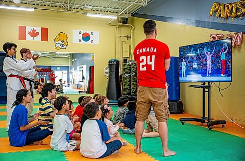 NIC ADAM / FREE PRESS
TRP Academy head instructor Steven Rivest (right) and the gym&#x2019;s ages 5-9 summer camp watch Winnipegger Skylar Park receive her bronze medal at the 2024 Paris Olympics.
240808 - Thursday, August 08, 2024.

Reporter: ?
