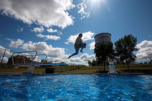 08082024
Karter Henderson leaps off the diving board at the Kinsmen Centennial Pool in Brandon&#x2019;s Rideau Park while swimming with his cousin Leland Henderson on a windy Thursday.  
(Tim Smith/The Brandon Sun)