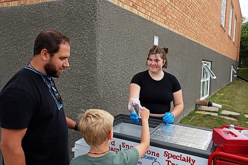 08082024
Ally Humphries hands Benjamin Korban an ice-cream as his dad Jay looks on while the Korban family from Rossburn enjoys Sandy Lake Western Days at Sandy Lake, Manitoba on Friday. Western Days runs until Sunday with a variety of town events and entertainment. 
(Tim Smith/The Brandon Sun)