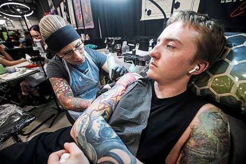 JOHN WOODS / FREE PRESS
Ashton Lutz gets a tattoo from Anastasia Powell of Beehaven Ink in Edmonton during the Winnipeg Tattoo Convention at Red River Exhibition Park Sunday, August 11, 2024. More than 250 tattoo artists from around the globe came together to practice their craft.

Reporter: ?