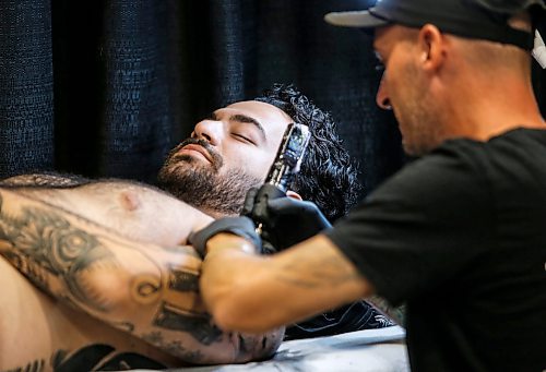 JOHN WOODS / FREE PRESS
Nima gets a tattoo from Mosh who traveled from Minorca, Spain during the Winnipeg Tattoo Convention at Red River Exhibition Park Sunday, August 11, 2024. More than 250 tattoo artists from around the globe came together to practice their craft. The pair had been working on ideas long distance for a couple of weeks prior to the show.

Reporter: ?