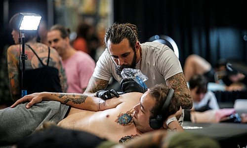 JOHN WOODS / FREE PRESS
Tyson Nurse gets a tattoo from Jeremiah Hoest of Left Coast Tattoo in Victoria during the Winnipeg Tattoo Convention at Red River Exhibition Park Sunday, August 11, 2024. More than 250 tattoo artists from around the globe came together to practice their craft.

Reporter: ?