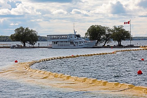 The containment curtain set up to prevent the spread of zebra mussels in Clear Lake is seen last Friday along with the Martese cruise boat at the marina, which is docked for the season as part of the mitigation efforts. (Tim Smith/The Brandon Sun)