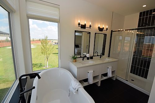 Todd Lewys / Winnipeg Free Press



A freestanding soaker tub combines with a six-foot tiled walk-in shower and elegant vanity to make the ensuite a relaxing, spa-like space.

