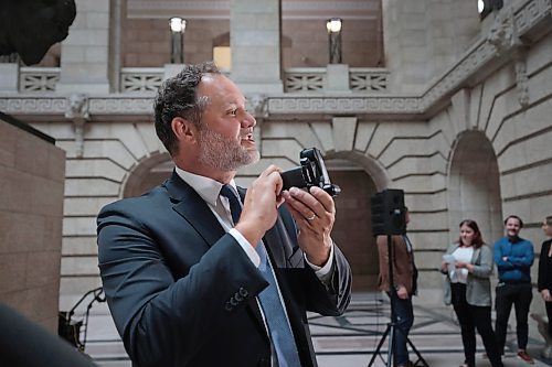 Justice Minister Matt Wiebe holds up an electronic monitoring device during a press conference in the rotunda at the Legislative Building on Wednesday. (Ruth Bonneville/Winnipeg Free Press)
