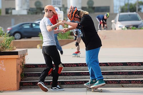 Jesi Wood with Recovery Skateshop helps 12-year-old Airianna Nicholson of Brandon learn to skateboard at the Kristopher Campbell Memorial Skate Plaza in downtown Brandon on Wednesday morning during a week-long beginners' skate camp put on by Recovery Skateshop. Recovery is running a similar camp for intermediate skateboarders next week. The recent Paris Olympics featured both men’s and women’s skateboarding events for the second time in Olympic history. (Tim Smith/The Brandon Sun)