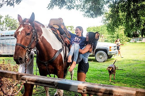 MIKAELA MACKENZIE / FREE PRESS

	
Kimisha Scott helps Alyssa Selman up on to her horse, Duke, on Tuesday, Aug. 13, 2024.

For Mike McIntyre story.