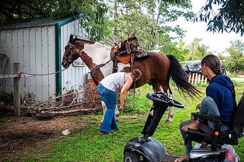 MIKAELA MACKENZIE / FREE PRESS

	
Amy Scott figures out how to best make a back cinch work for Alyssa Selman&#x573; customized saddle on Duke on Tuesday, Aug. 13, 2024.

For Mike McIntyre story.