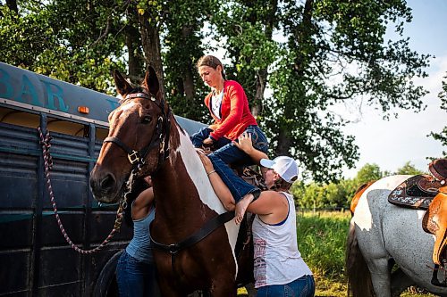 MIKAELA MACKENZIE / FREE PRESS

	
Amy Scott helps her sister Alyssa Selman get up into her saddle before warming up at the Denim &amp; Dust Barrel Racing Series in Carman on Tuesday, Aug. 13, 2024.

For Mike McIntyre story.