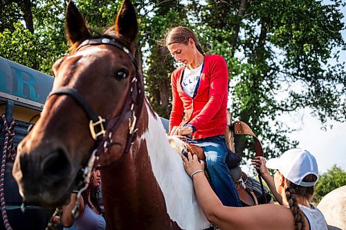 MIKAELA MACKENZIE / FREE PRESS

	
Amy Scott helps her sister Alyssa Selman get up into her saddle before warming up at the Denim &amp; Dust Barrel Racing Series in Carman on Tuesday, Aug. 13, 2024.

For Mike McIntyre story.