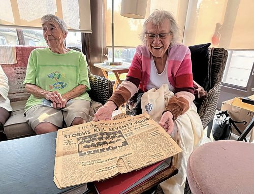 Zenny Burton (right), holds out a Brandon Sun newspaper from May 26, 1955 showing the front page that featured a photo of her graduating class from nursing school at the Brandon General Hospital. Sitting beside Burton is one of her 12 classmates, Rose Evans. (Michele McDougall/The Brandon Sun)