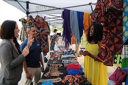 Sumatu Intercontinental Traditional Wears owner Ramatu Suma (right) tells Westman Immigrant Services executive director Enver Naidoo and Downtown BIZ executive director Emmy Sanderson about her fabrics displayed at the Downtown Summer Market at 1001 Pacific Ave. on Friday. (Abiola Odutola/The Brandon Sun)