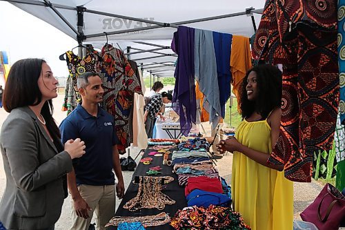 Sumatu Intercontinental Traditional Wears owner Ramatu Suma (right) tells Westman Immigrant Services executive director Enver Naidoo and Downtown BIZ executive director Emmy Sanderson about her fabrics displayed at the Downtown Summer Market at 1001 Pacific Ave. on Friday. (Abiola Odutola/The Brandon Sun)