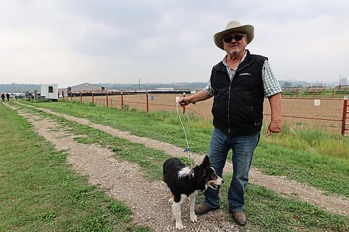 Campbell Forsyth stands with his dog Mac at the Minnedosa Agricultral Grounds. The two competed at the 2024 Show and Sale on Friday, going for the fastest time and highest accuracy herding sheep through barrels and into a pen. (Connor McDowell/Brandon Sun)