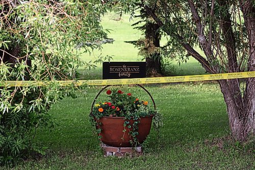 Behind the yellow tape on the rural property, a family sign is attached to a flower planter. (Tim Smith/The Brandon Sun)