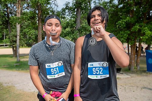 BROOK JONES / FREE PRESS
Fifteen-year-old Phoenix Abraham (left) and 17-year-old Brad Courchene, who are both from Sagkeeng First Nation, show their finisher medals after competing in the Free Spirit Sprint Triathlon in Pinawa, Man., Sunday, Aug. 11, 2024.