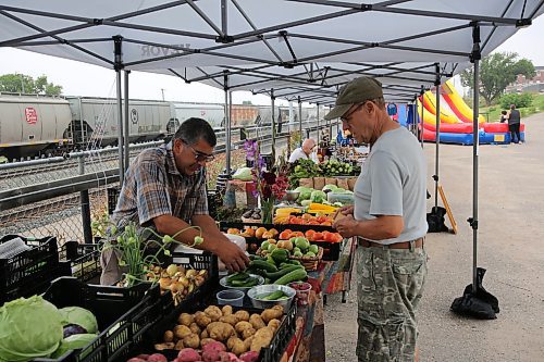 Left: Willow Lane Garden owner Alan Pleit attends to a patron at the Downtown Summer Market at 1001 Pacific Ave. on Friday. (Abiola Odutola/The Brandon Sun)