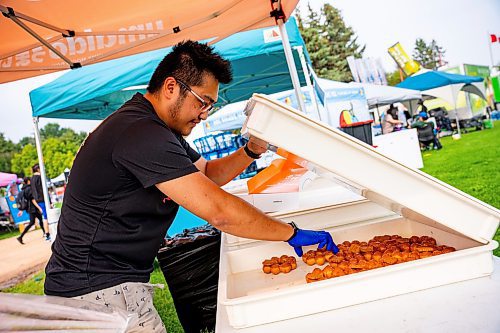 NIC ADAM / FREE PRESS
Nathaniel Delacruz, of Umaido, prepares boxes of donuts for customers at Winnipeg&#x2019;s Streat Feast Festival at the Forks Friday afternoon. 
240816 - Friday, August 16, 2024.

Reporter: ?