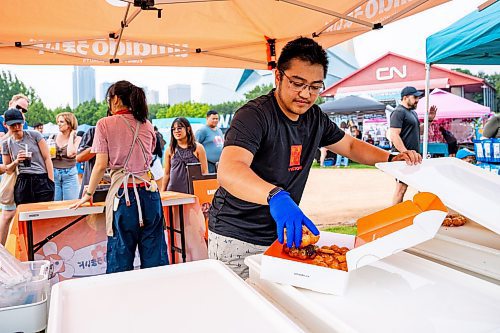 NIC ADAM / FREE PRESS
Nathaniel Delacruz, of Umaido, prepares boxes of donuts for customers at Winnipeg&#x2019;s Streat Feast Festival at the Forks Friday afternoon. 
240816 - Friday, August 16, 2024.

Reporter: ?