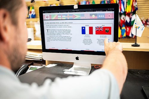 MIKAELA MACKENZIE / WINNIPEG FREE PRESS
	
Mathew Hobson, a sales associate at The Flag Shop on Osborne, shows a North American Vexillological Association booklet on flag design on Monday, Aug. 19, 2024. According to a Probe Research poll, 49% of Manitobans would support creating a new flag for the province.

Winnipeg Free Press 2024