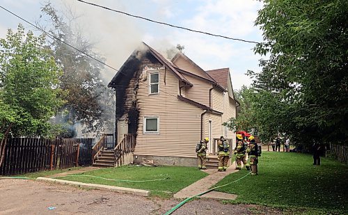 Firefighters set to work tackling a house fire on the 200 block of First Street on Sunday afternoon. On Monday, Brandon Police Service said they're investigating whether the fire was caused by squatters setting a campfire next to the home's fence. (Colin Slark/The Brandon Sun)