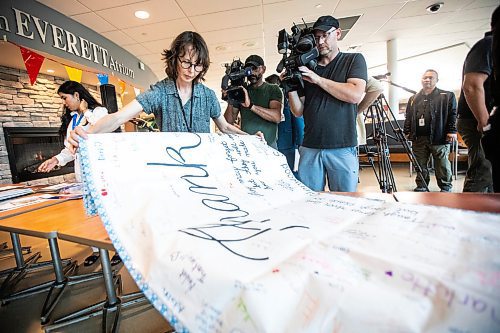 MIKAELA MACKENZIE / WINNIPEG FREE PRESS
	
Curator hannah_g folds a banner to go into a time capsule remembering the COVID-19 pandemic and the healthcare workers that held steadfast during that time at the St. Boniface Hospital on Tuesday, Aug. 20, 2024.

Winnipeg Free Press 2024