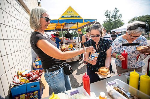 MIKAELA MACKENZIE / WINNIPEG FREE PRESS
	
Andrea Nowosad (left) and her daughter, Nancy Hamilton, grab food at the DASCH Inc. and DASCH Foundation 50th anniversary barbecue at the Norwood Community Centre on Tuesday, Aug. 20, 2024.

Winnipeg Free Press 2024