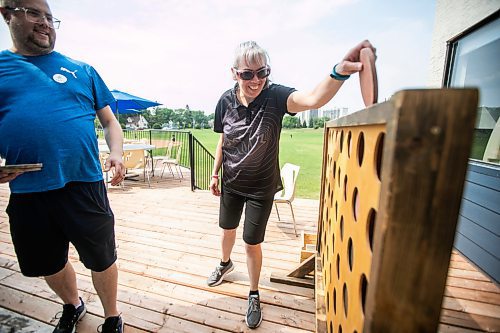 MIKAELA MACKENZIE / WINNIPEG FREE PRESS
	
Richard Kowalchuk, director of centralized services for DASCH (left), and Jenny Adams (who lives in a DASCH home) play yard games at the DASCH Inc. and DASCH Foundation 50th anniversary barbecue at the Norwood Community Centre on Tuesday, Aug. 20, 2024.

Winnipeg Free Press 2024