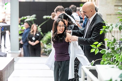 MIKAELA MACKENZIE / WINNIPEG FREE PRESS
	
WRHA CEO Mike Nader cloaks Allison Afable in the white-coat ceremony for the newest University of Manitoba medical class at the Max Rady College of Medicine on Wednesday, Aug. 21, 2024.

For Jura story.
Winnipeg Free Press 2024