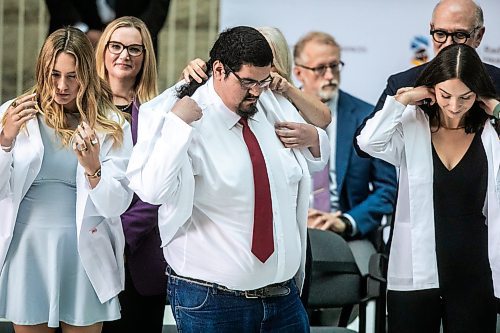 MIKAELA MACKENZIE / WINNIPEG FREE PRESS
	
Kelsey West dons his first white coat in a ceremony for the new University of Manitoba medical students at the Max Rady College of Medicine on Wednesday, Aug. 21, 2024.

For Jura story.
Winnipeg Free Press 2024