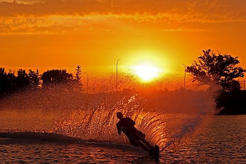 21082024
Herman Lepp with the Brandon Waterski Club kicks up a wall of spray while slalom skiing on the Assiniboine River in Brandon as the sun rises over the horizon early Wednesday morning. 
(Tim Smith/The Brandon Sun)