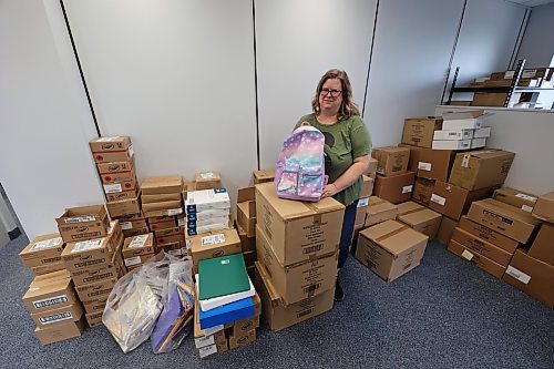 United Way Brandon chief executive officer Cynamon Mychasiw takes a picture with the supplies for kids that will be shared by end of August. (Abiola Odutola/The Brandon Sun)