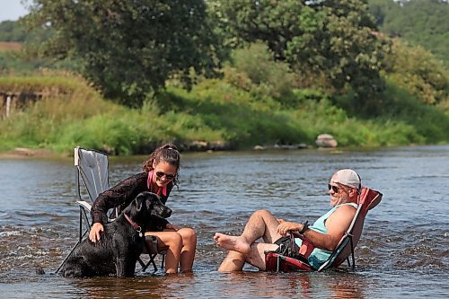 Victoria and Stephen Findlay cool their heels in the Little Saskatchewan River along with their dog Wesley on a hot Friday afternoon. (Tim Smith/The Brandon Sun)