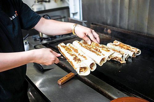 MIKAELA MACKENZIE / WINNIPEG FREE PRESS
	
Riwas Kahil makes chicken shawarma wraps at Danook Restaurant on Friday, Aug. 23, 2024. The Syrian establishment has a tipping prompt, which helps staff; the restaurant can't afford to pay staff higher wages without raising its menu prices, the owner said. 

For Gabby story.
Winnipeg Free Press 2024