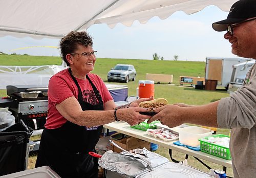 Heather Manuliak hands a pulled pork sandwich to David Lesack during the 11th annual fundraising barbeque for Special Olympics, hosted by Heather and her husband Murray at the Brandon Riverbank Discovery Centre on Saturday. (Michele McDougall/The Brandon Sun)
