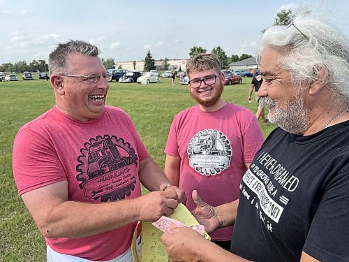 Murray Manuliak (left) and his grandson Alex sell 50/50 tickets to Mark Tricco during the 11th annual fundraising barbeque for Special Olympics, Murray and his wife Heather at the Brandon Riverbank Discovery Centre on Saturday. (Michele McDougall/The Brandon Sun)