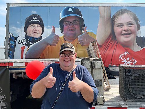 Stephen Campbell, Westman Special Olympian poses in front of the trailer with his photo on it that was taken when he competed in the Special Olympics Canada 2014 Summer Games in Vancouver. Campbell attended the 11th annual fundraising barbeque for Special Olympics, hosted by Murray and Heather Manuliak at the Brandon Riverbank Discovery Centre on Saturday. (Michele McDougall/The Brandon Sun)
